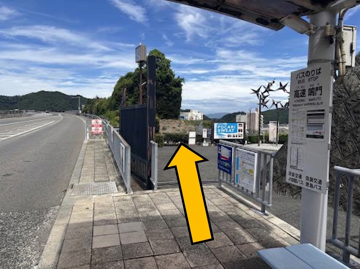 高速鳴門バス停（徳島方面行き）の降り場。黄色い矢印が正面奥へ進む方向を示している